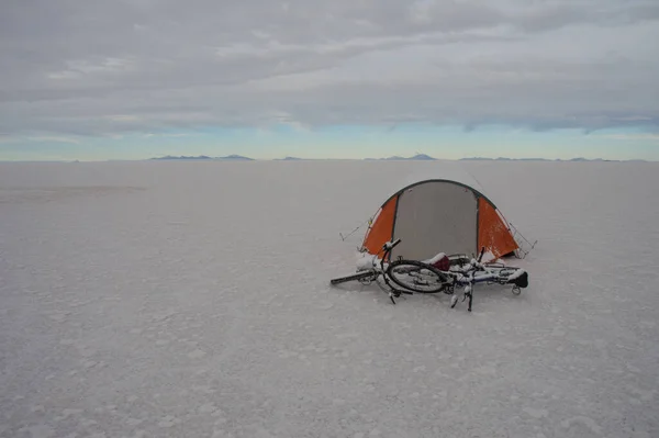 tent and bicycles with snow in the salt desert in Bolivia