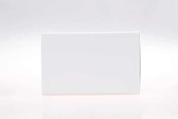 Пакет из картона с пилюлями или капсулами на сером фоне — стоковое фото