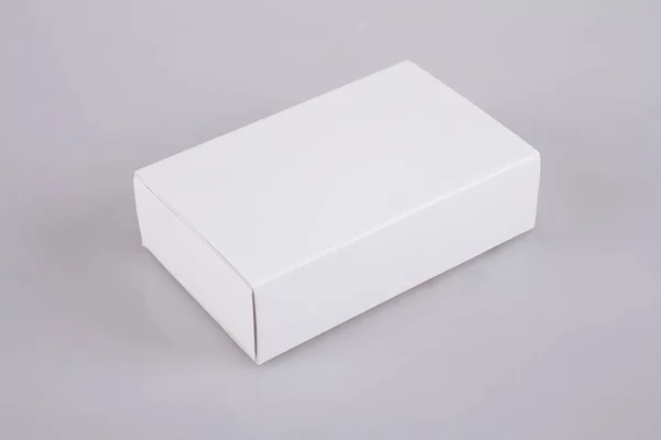 Κλειστό λευκό χάρτινο κουτί σε γκρίζο φόντο — Φωτογραφία Αρχείου