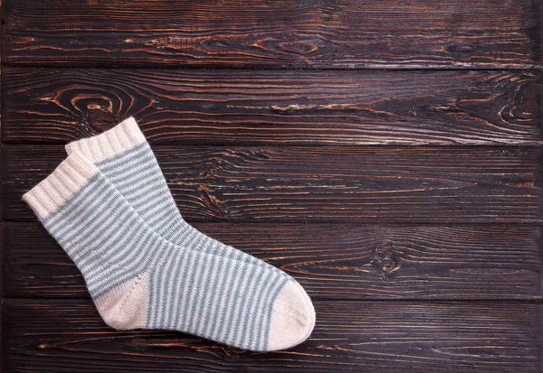 Jedny bílé ponožky s lehkým modrým pruhem na dřevěné pozadí — Stock fotografie