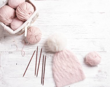 El yapımı örgü pembe şapka ile ahşap bir masa üzerinde kürk pon pon ile