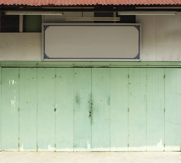 Porta verde com tabuleta vazia — Fotografia de Stock