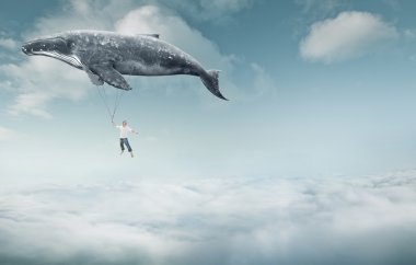 man and big whale flying over clouds