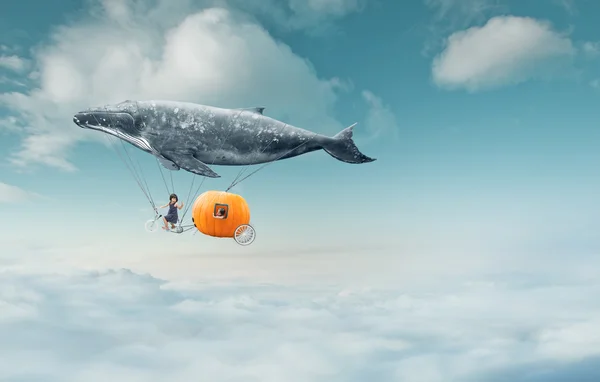 Whale with pumpkin and two girls over clouds — Stockfoto