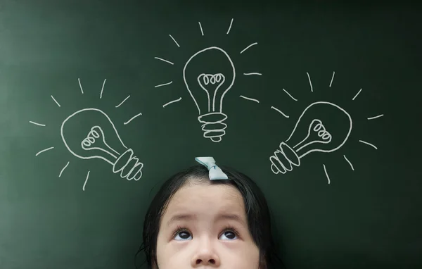 Niña mirando por encima de la pizarra — Foto de Stock