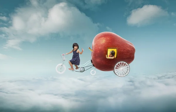 Гігантське яблуко і дві дівчини над хмарами — стокове фото