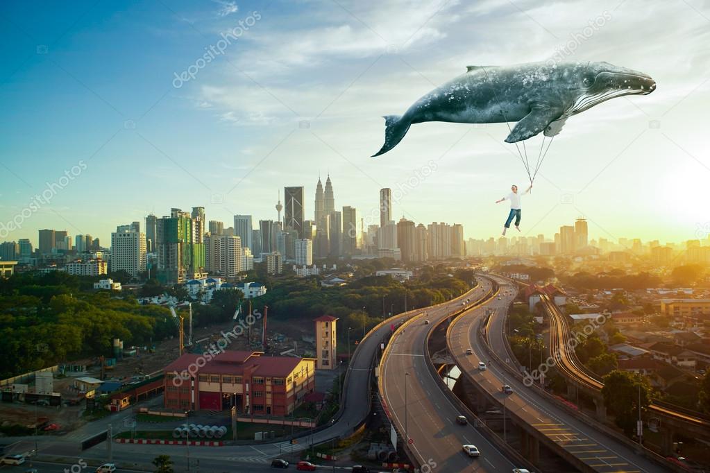 man and big whale flying over cityscape