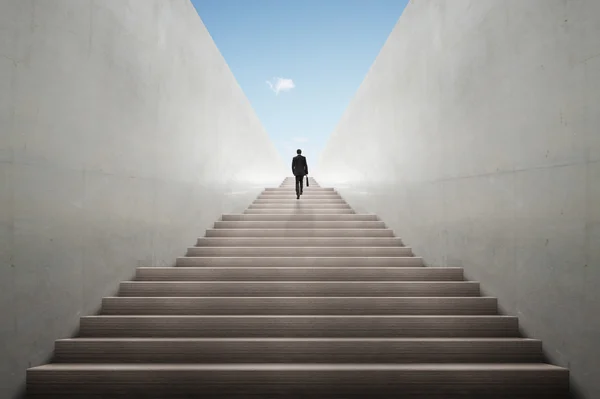 Концепция амбиций с бизнесменом, поднимающимся по лестнице — стоковое фото