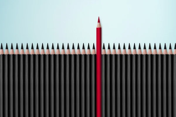 Red pencil standing out from black — Stockfoto