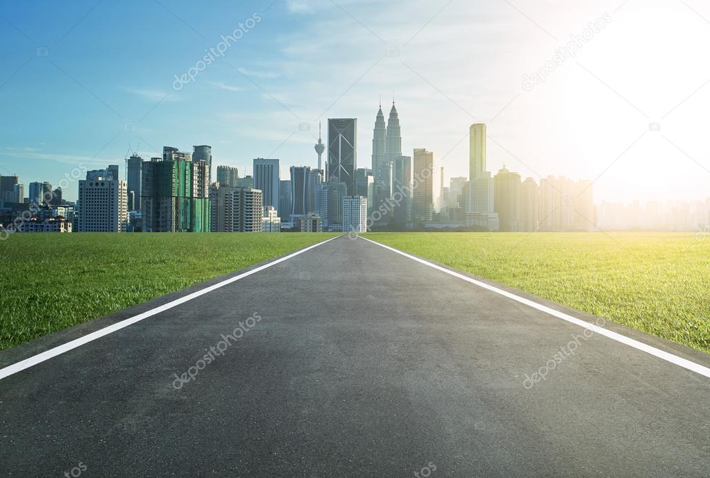 Asphalt road leading to a city 