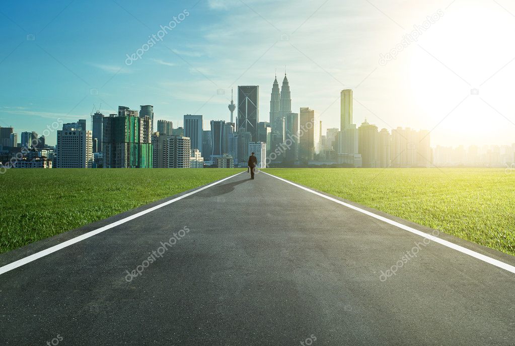 Man walking on the road towards city