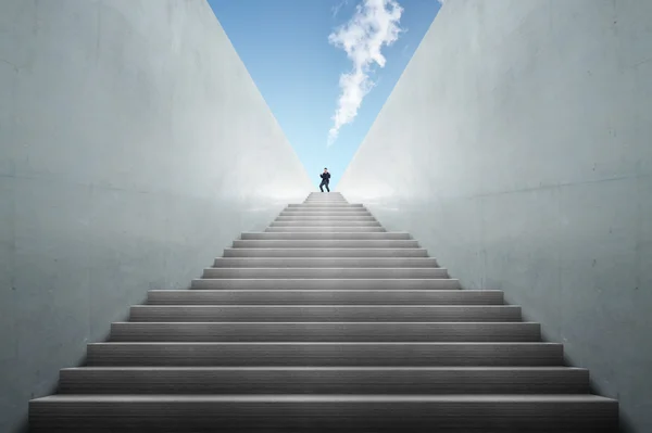 Ambitions concept with businessman climbing stairs