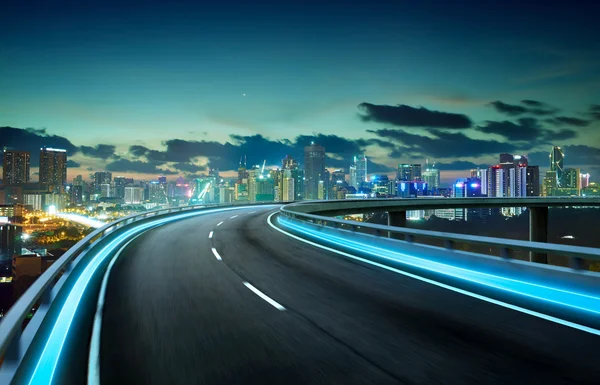 Autopista de luz de neón sobre paisaje urbano — Foto de Stock