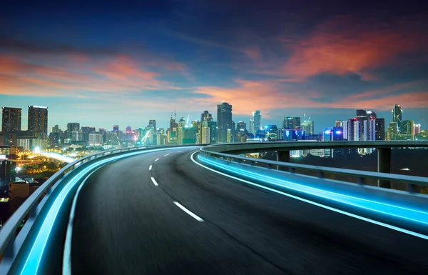 Autopista de luz de neón sobre paisaje urbano —  Fotos de Stock