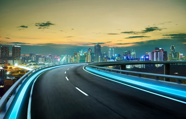 Neon licht snelweg over stadsgezicht — Stockfoto