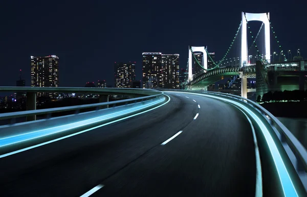 Estrada da luz do néon sobre a paisagem urbana — Fotografia de Stock