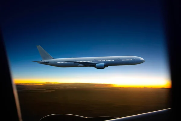 Avión sobre las nubes al atardecer — Foto de Stock