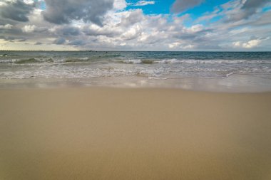 Kumlu sahilde yumuşak dalgalar