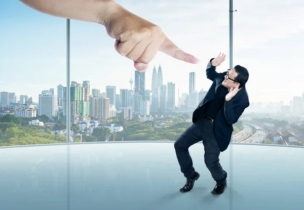 Empresário em uma pose de susto e uma mão gigante — Fotografia de Stock