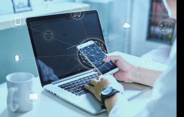 Telefon ve dizüstü bilgisayar kullanan adam