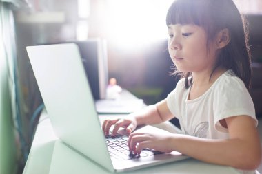 dizüstü bilgisayar kullanan küçük Asyalı kız 