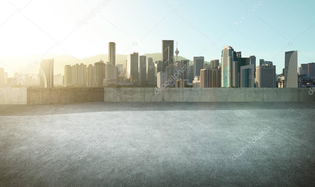 Empty asphalt carpark with city skyline