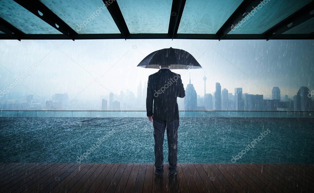 Businessman holding umbrella