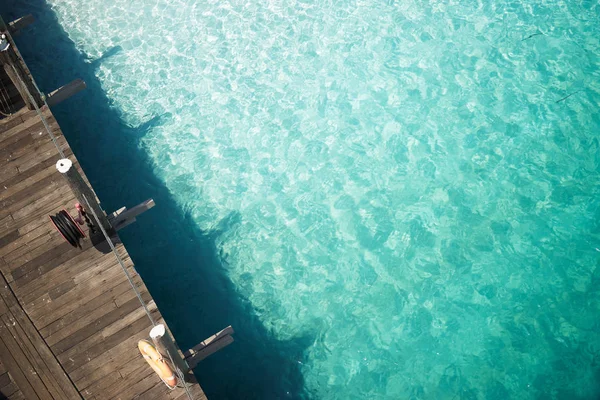 Wooden jetty with crystal clear water — Stock Photo, Image