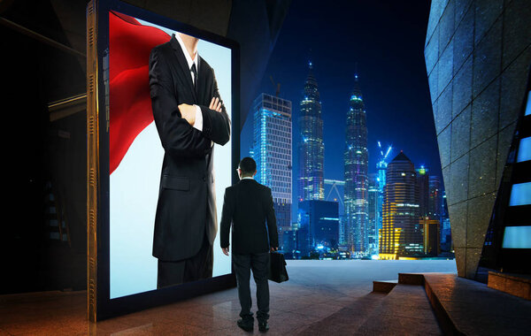Young businessman looking the hero businessman on the advertising billboard screen