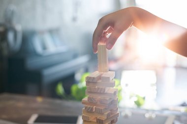 bir blok ahşap kule oynayan çocuk 