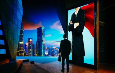 Young businessman looking the hero businessman on the advertising billboard screen . Successful businessman concept . clipart