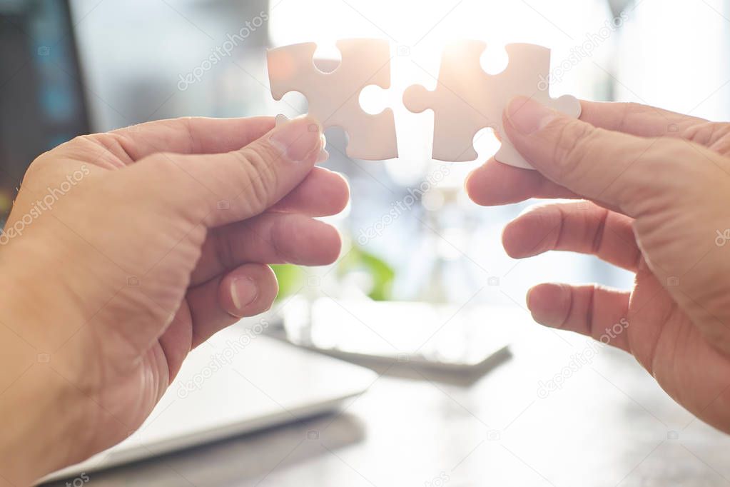 businessman connecting puzzle pieces
