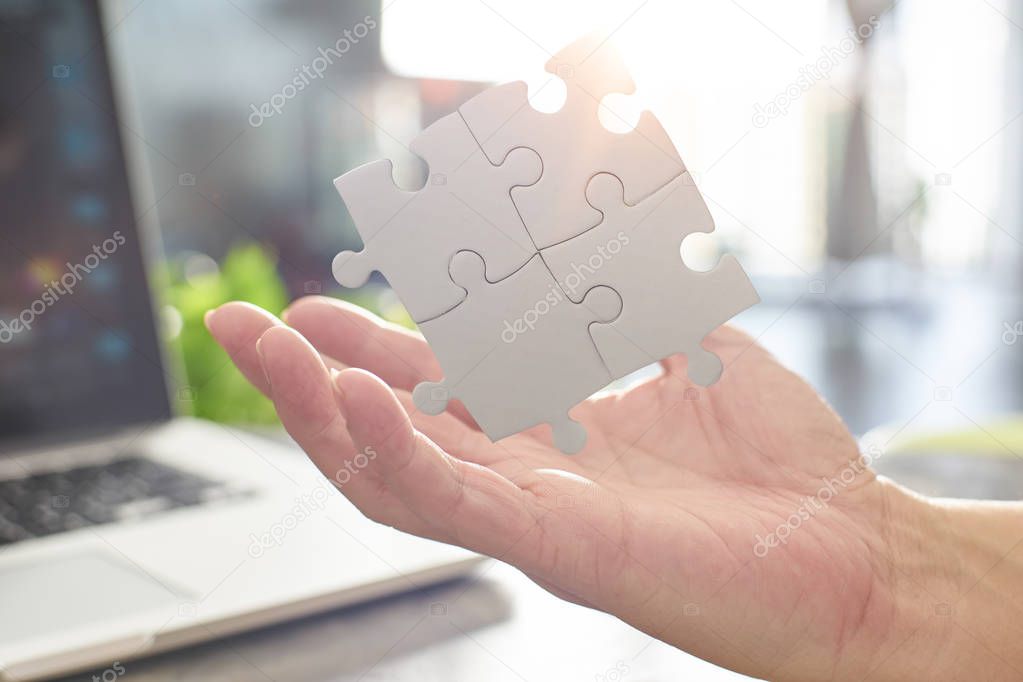 businessman connecting puzzle pieces