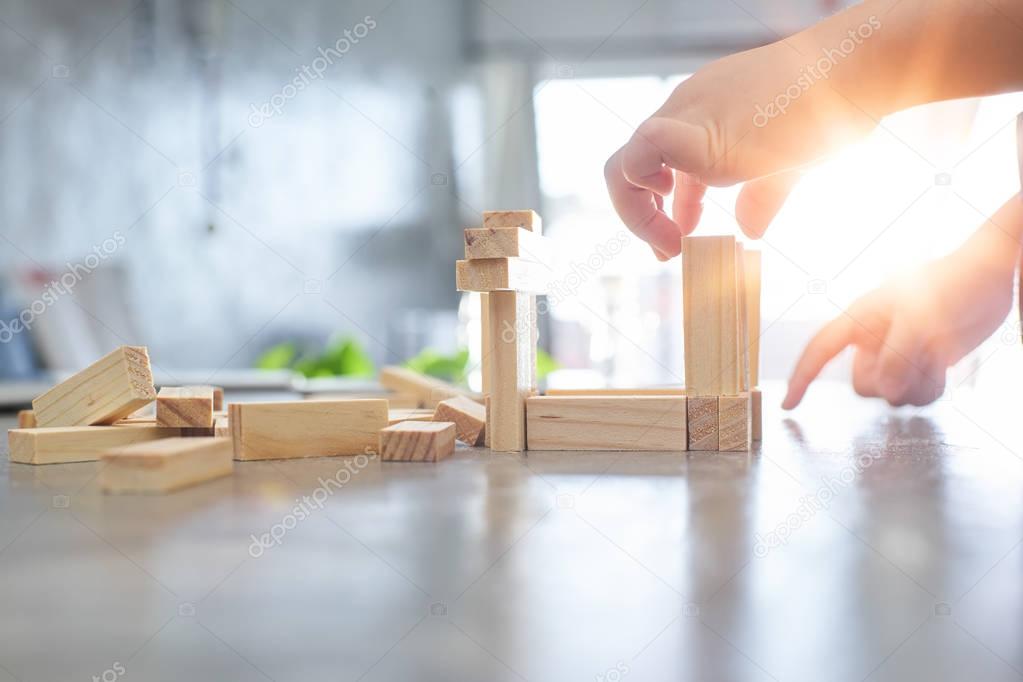 kid playing a blocks wood tower 