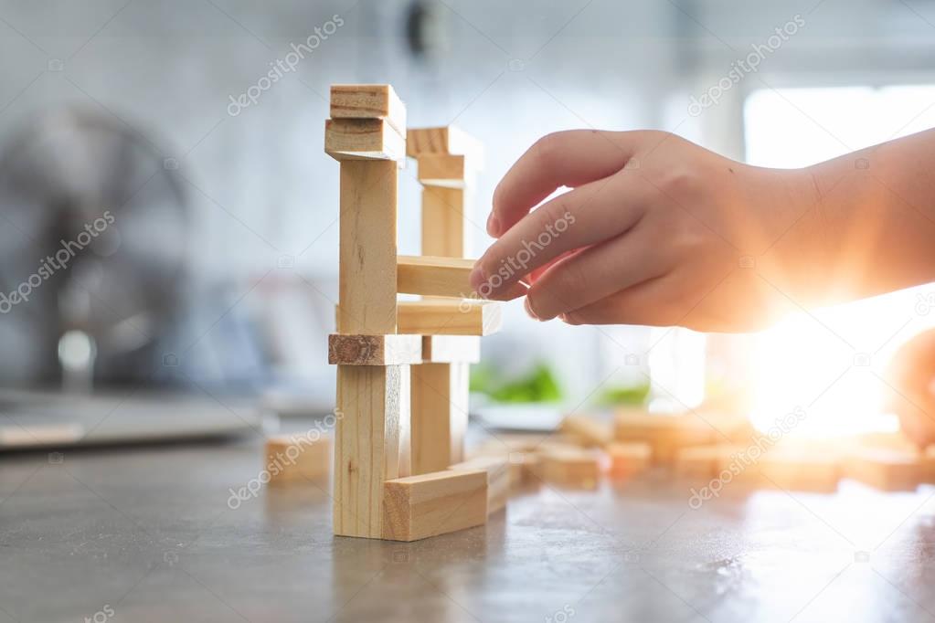 kid playing a blocks wood tower 