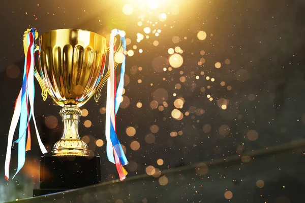 Soyut parlak ışıklar ile bulanıklık gri arka plan üzerinde düşük anahtar Altın Kupa .