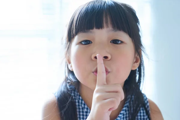 Meisje haar vinger te houden aan haar lippen — Stockfoto