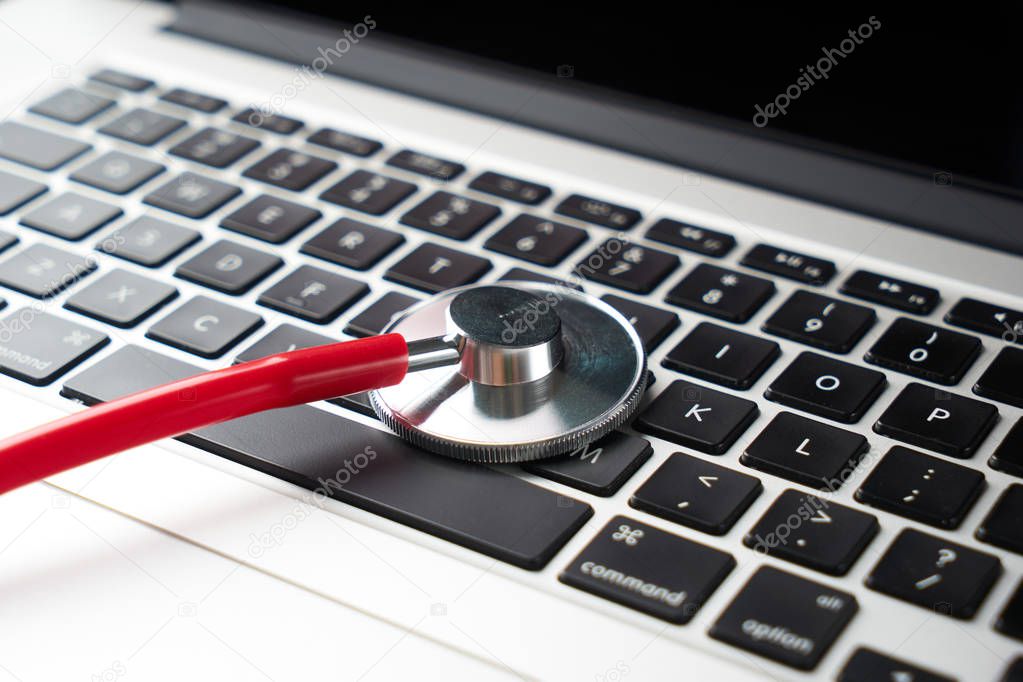 Closeup laptop diagnosis with a stethoscope. computer repair and service concept.