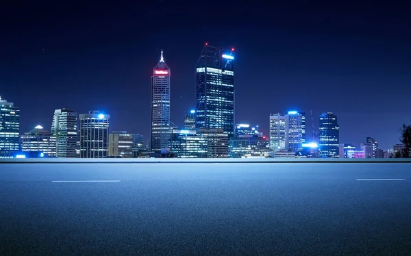 Side view asphalt road on snight scene near the modern city .