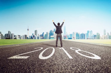 2018 yeni yıl, genç işadamı tezahürat şehir manzarası arka plan ile. Yenileyin ve kavram umut .