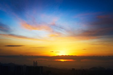 Güzel doğal günbatımı gündoğumu siluetleri şehir manzarası ve muhteşem turuncu bulut mavi gökyüzü üstündeki .