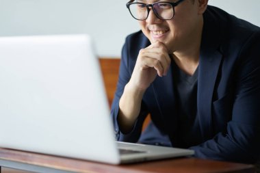 Bilgisayar önünde gülümseyen iş adamı