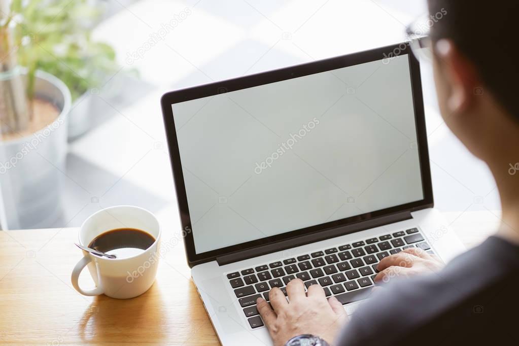 Laptop in businessman hand with coffee .