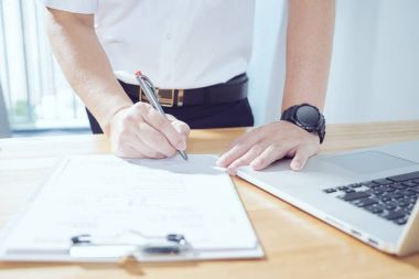 Büyük bir projeyi imzalamak için dizüstü bilgisayar ve yapmak karar kullanarak iş adamı .