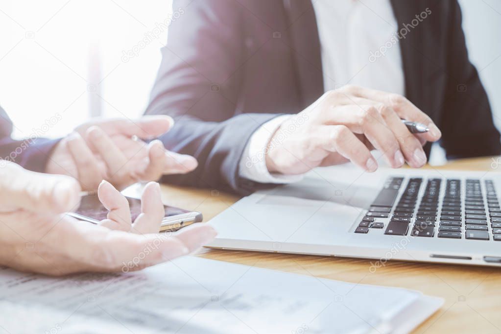 Two businessman using laptop to discuss finance and marketing solution .