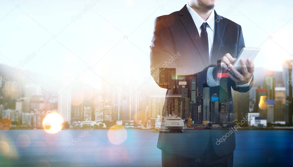 Portrait of businessman using smartphone.Double exposure effect with Hong Kong city skyline business center view at sunrise .