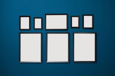 Asılı sekiz boş resim çerçeveleri duvar arka plan mavi