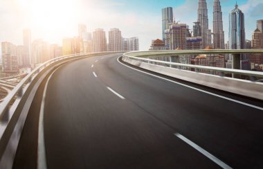 Hareket curvy üstgeçidin asfalt Otoban yol modern cityscape silüeti manzaralı. Sunrise sahne .