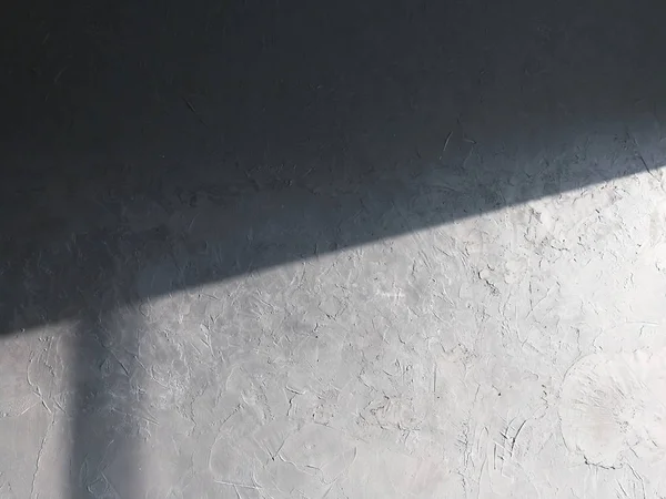 Light and shadow cast on cement wall