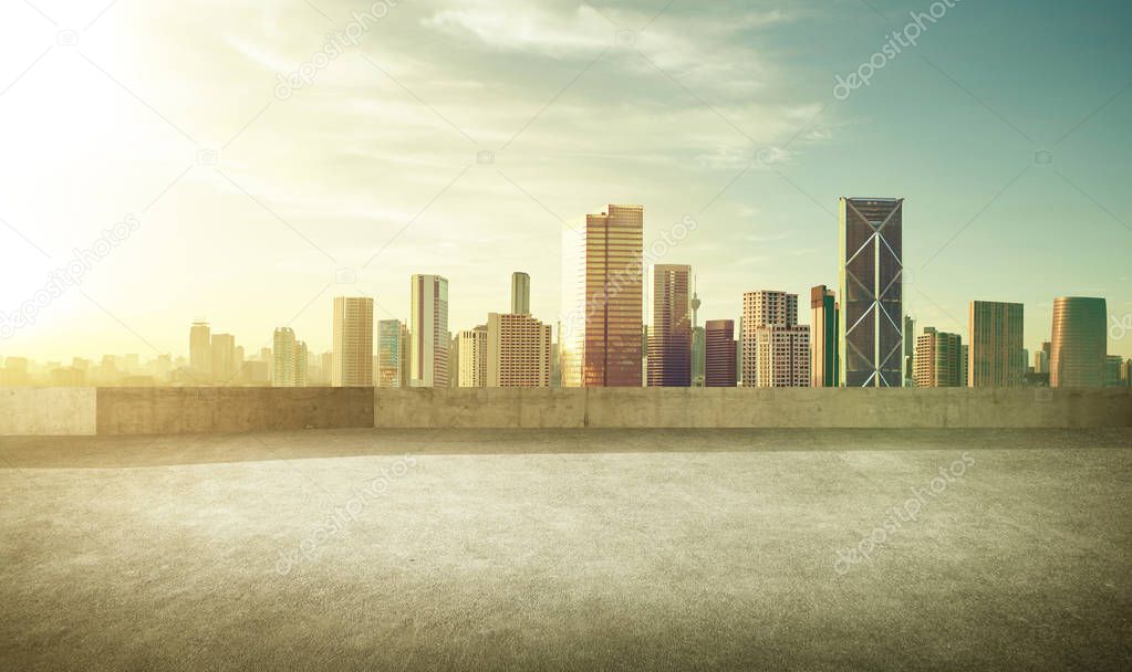 Empty asphalt carpark with modern city skyline, morning sunrise scene.